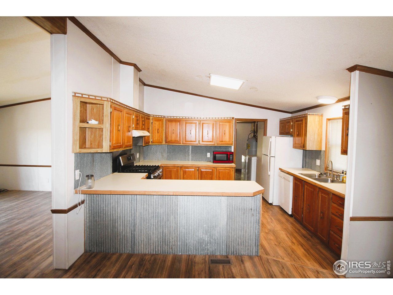 22354 County Road 41 Sterling, CO 80751 - Photo 31 of 40 a large kitchen with stainless steel appliances a refrigerator a sink dishwasher with wooden floor