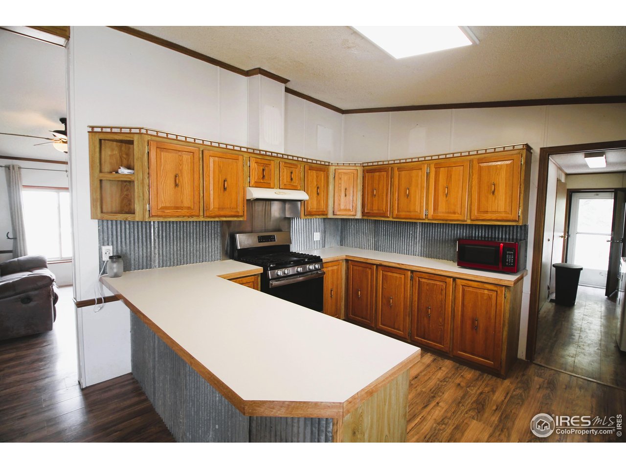22354 County Road 41 Sterling, CO 80751 - Photo 32 of 40 a kitchen with stainless steel appliances kitchen island granite countertop a refrigerator a sink dishwasher and wooden cabinets with wooden floor