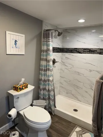 a white toilet sitting next to a bath tub and a shower