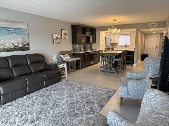 a living room with furniture and a view of kitchen