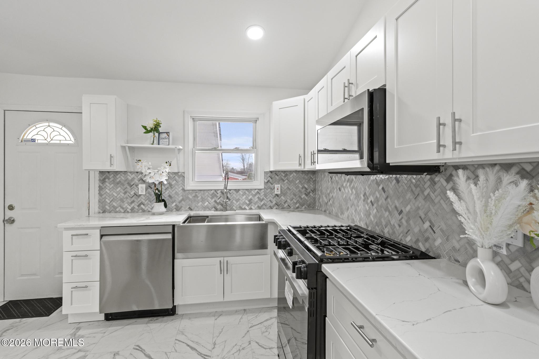 20 Kenneth Terrace Neptune Township, NJ 07753 - Photo 18 of 34 a kitchen with stainless steel appliances granite countertop a sink stove and cabinets