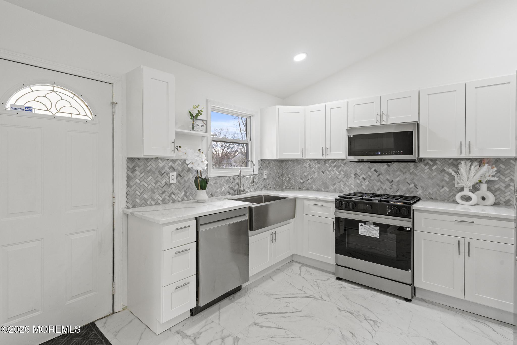 20 Kenneth Terrace Neptune Township, NJ 07753 - Photo 20 of 34 a kitchen with granite countertop white cabinets and stainless steel appliances