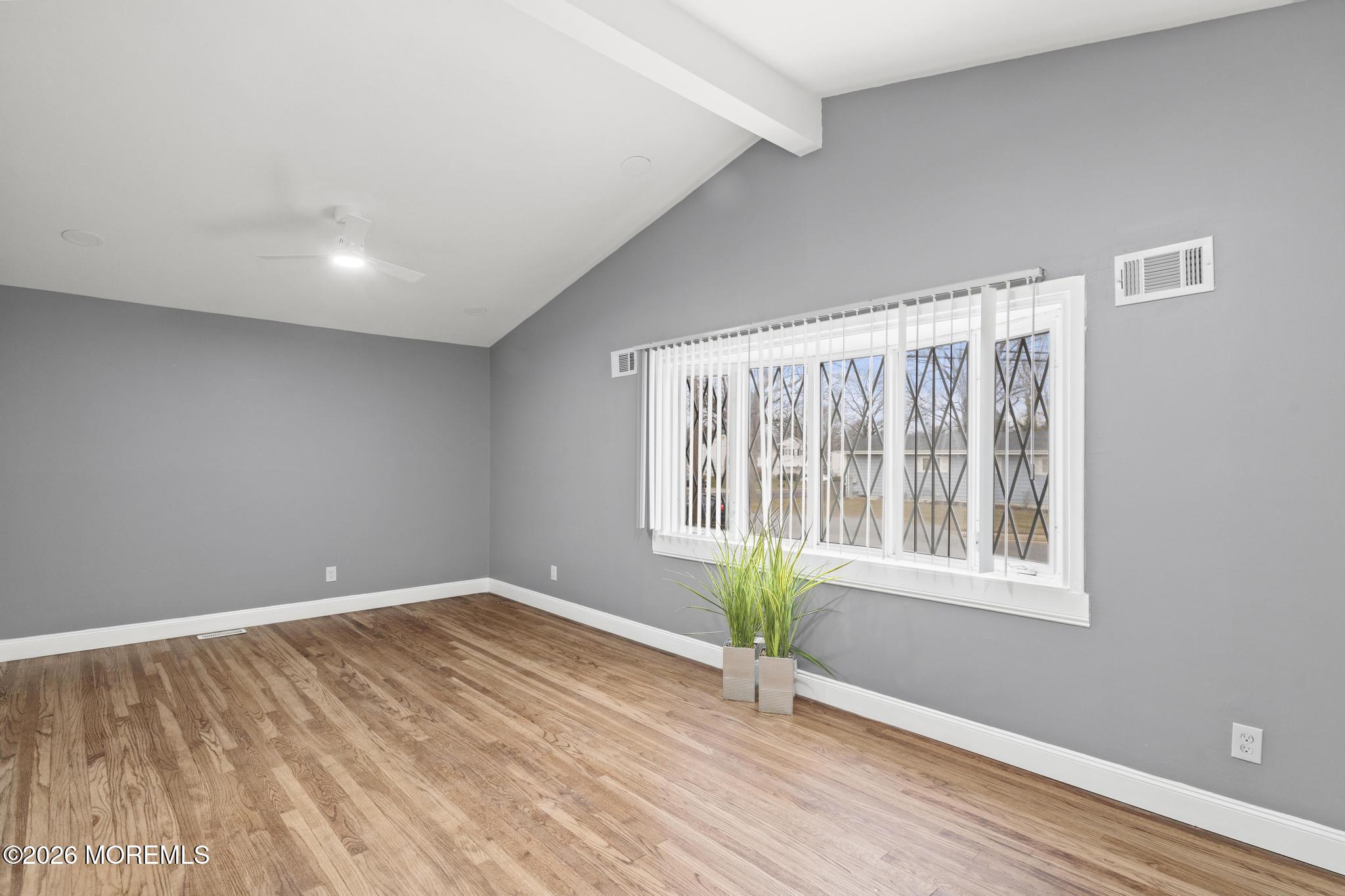 20 Kenneth Terrace Neptune Township, NJ 07753 - Photo 5 of 34 a view of an empty room with a window and wooden floor