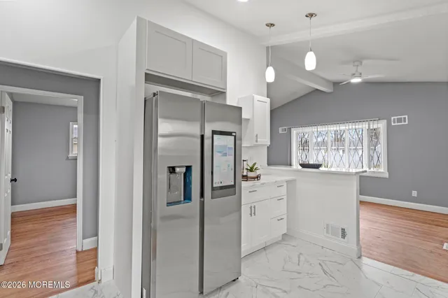 a kitchen with white cabinets and stainless steel appliances