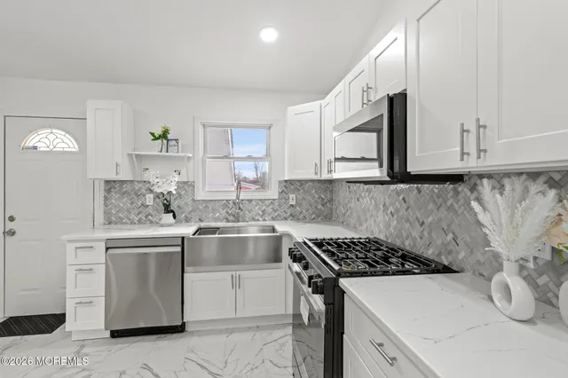a kitchen with stainless steel appliances granite countertop a sink stove and cabinets