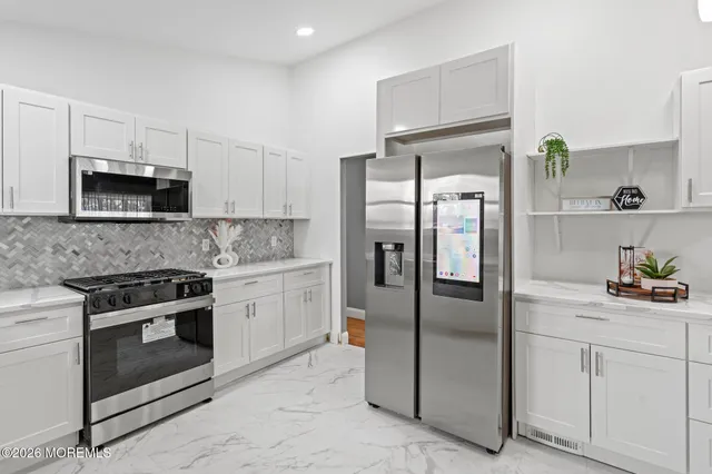 a kitchen with stainless steel appliances a refrigerator sink and microwave