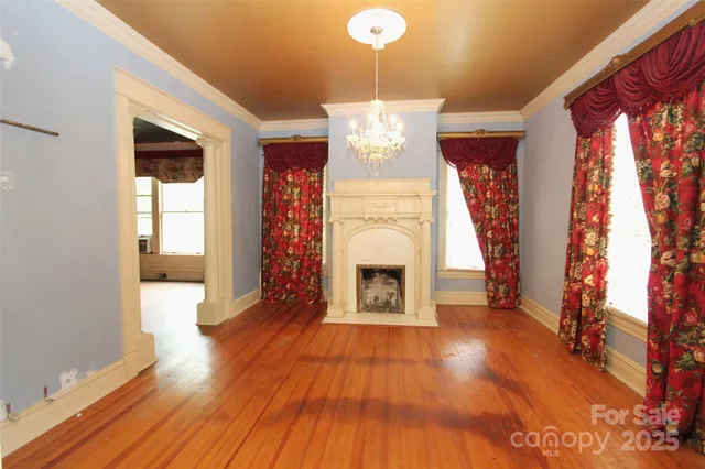 a view of a livingroom with wooden floor and a fireplace