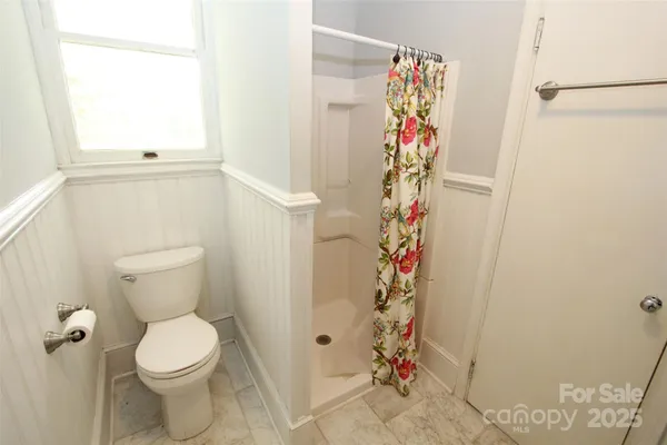 a bathroom with a toilet and a shower curtain