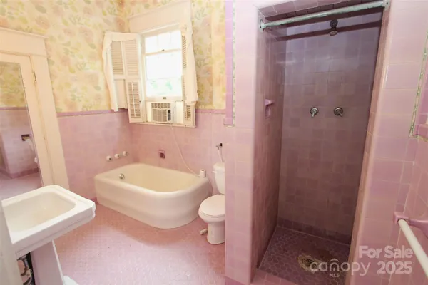 a bathroom with a sink a toilet a tub and shower
