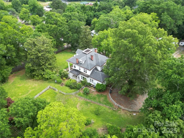 an aerial view of residential house with outdoor space and trees all around