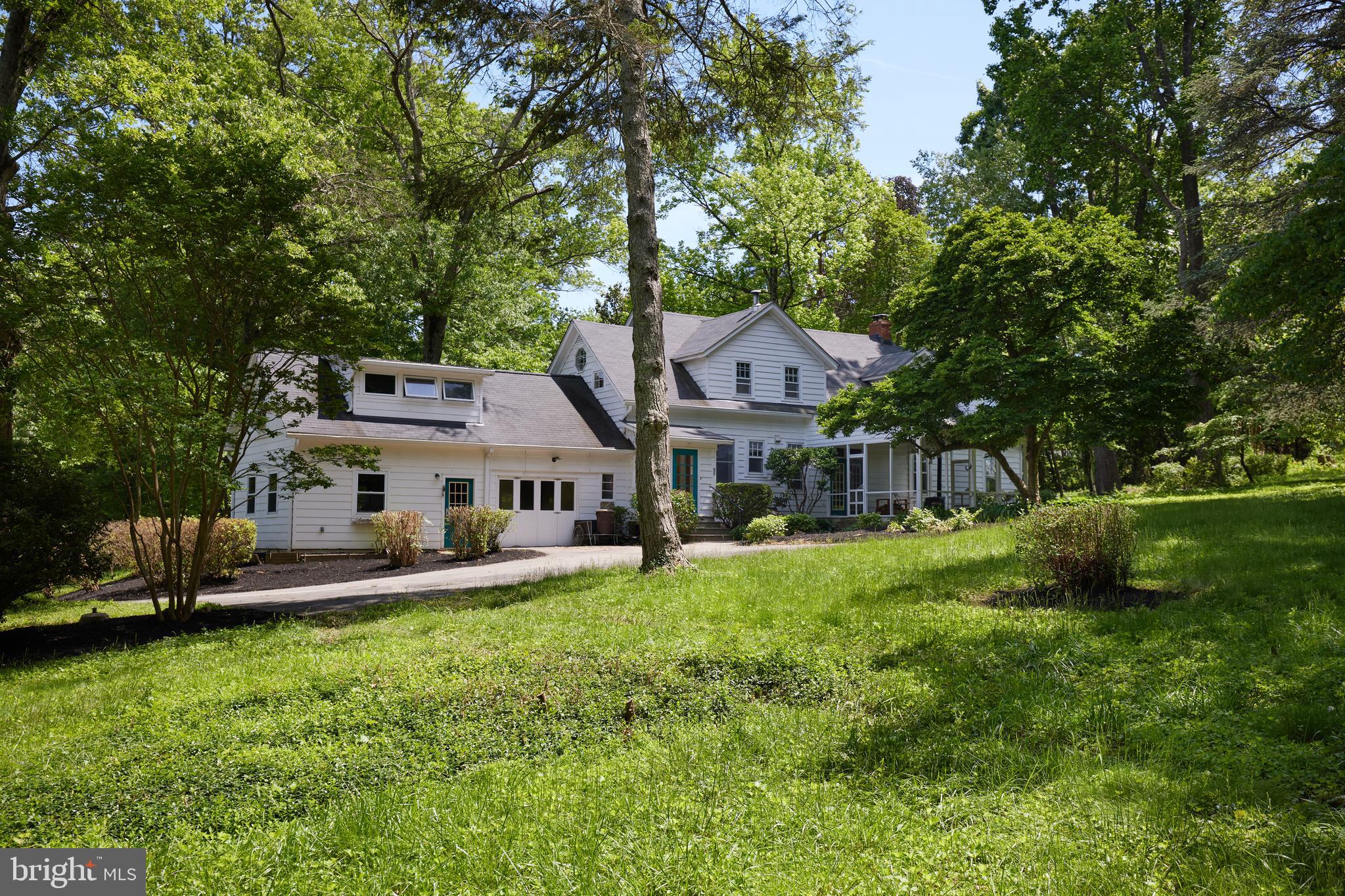 a front view of a house with a garden and trees