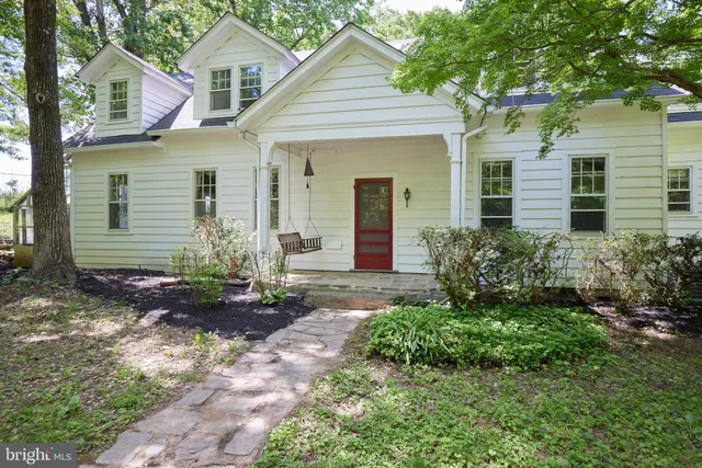 a front view of a house with a yard and potted plants