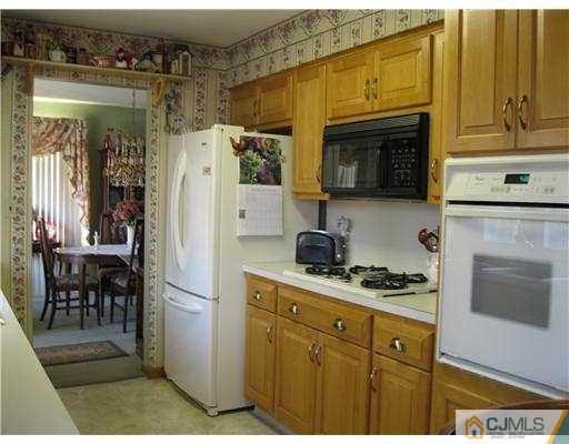 153 Oxford Road Colonia, NJ 07067 - Photo 2 of 13 a kitchen with cabinets and a refrigerator