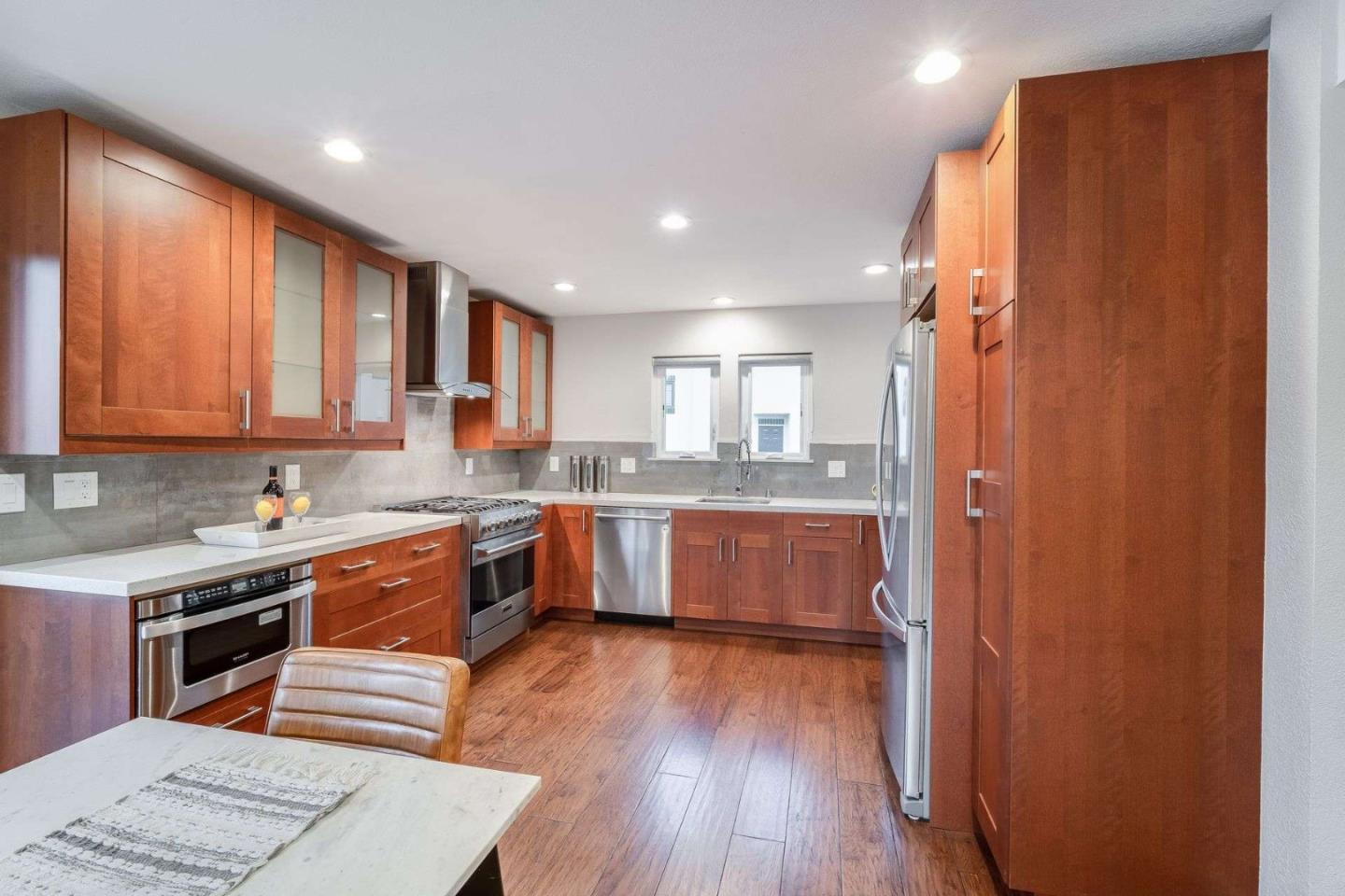 181 Centre Street, Unit 1 Mountain View, CA 94041 - Photo 5 of 58 a large kitchen with stainless steel appliances granite countertop a refrigerator a sink dishwasher a stove and white countertops with wooden floor