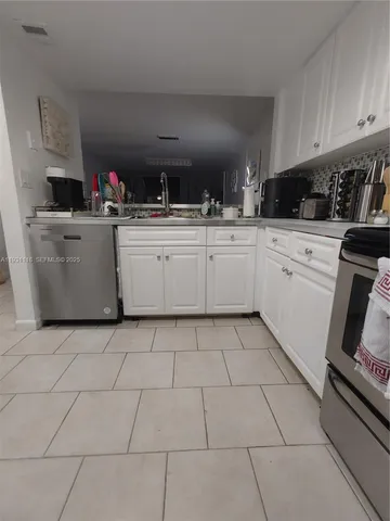 a kitchen with a sink and white cabinets