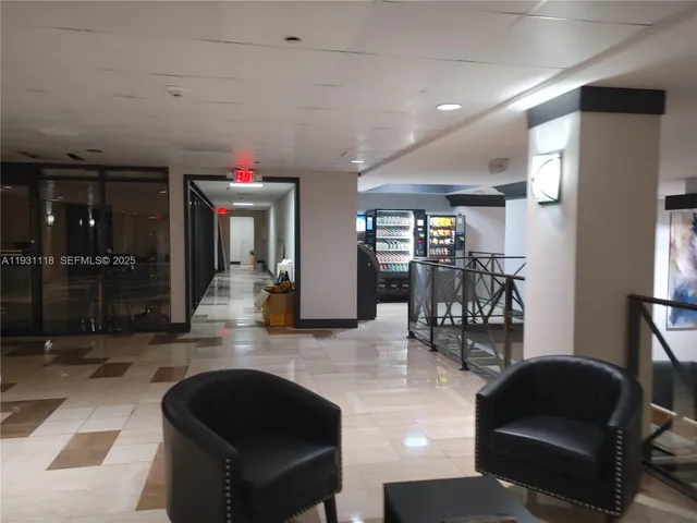 a living room with couches and kitchen view with wooden floor