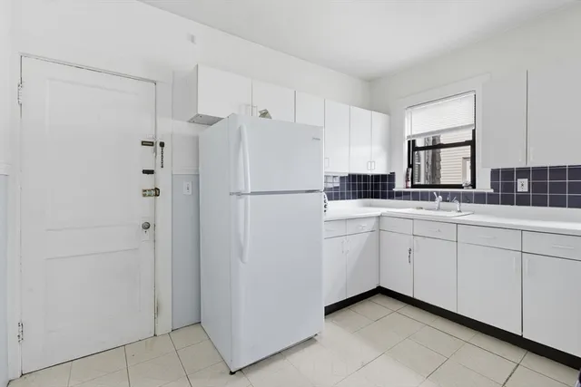 a kitchen with white cabinets and white appliances