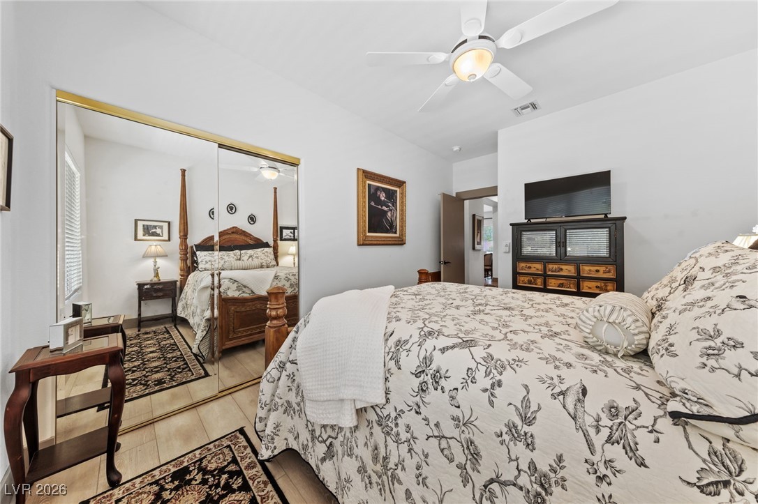 550 Kings Links Street Henderson, NV 89012 - Photo 18 of 36 Bedroom with light wood-style flooring, a closet, and a ceiling fan