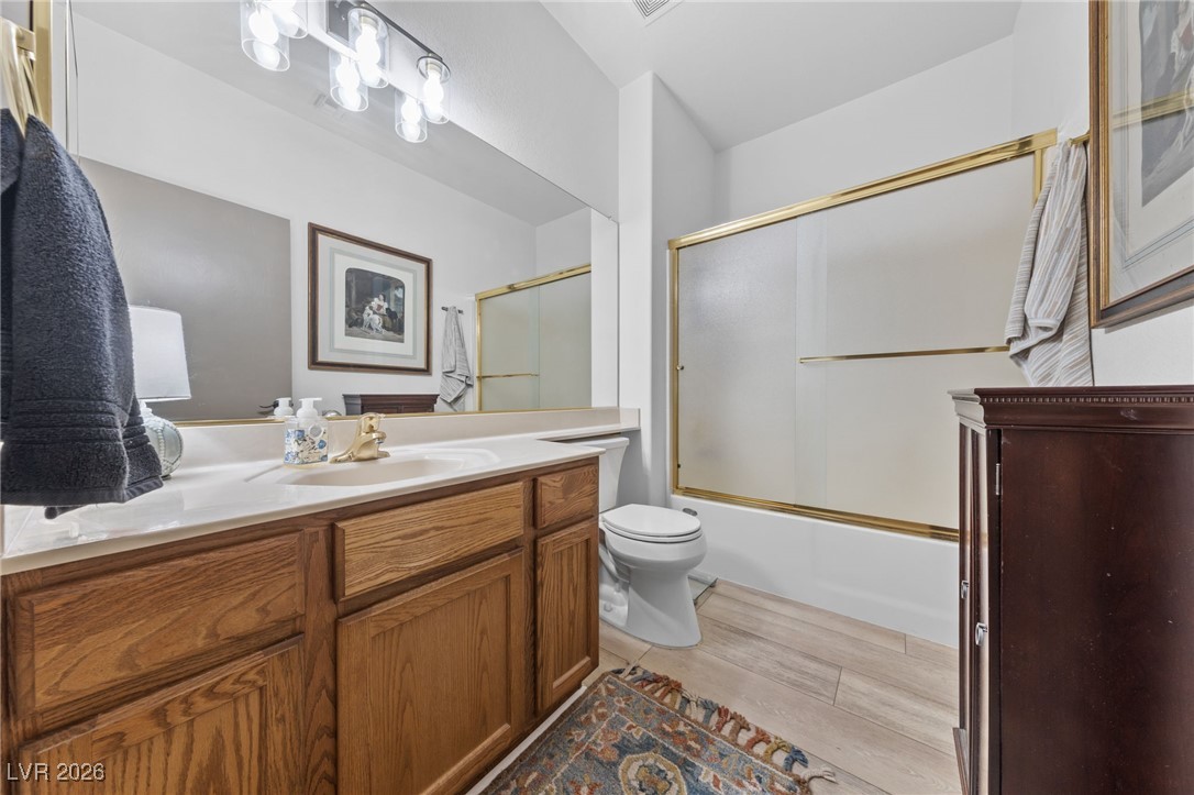 550 Kings Links Street Henderson, NV 89012 - Photo 20 of 36 Full bath featuring vanity, combined bath / shower with glass door, and wood finished floors