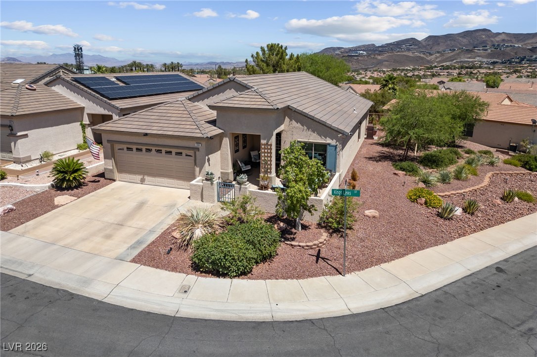 550 Kings Links Street Henderson, NV 89012 - Photo 2 of 36 Ranch-style house featuring a garage, concrete driveway, stucco siding, and a mountain view