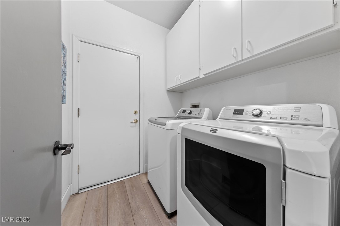 550 Kings Links Street Henderson, NV 89012 - Photo 21 of 36 Washroom with washing machine and clothes dryer, cabinet space, and light wood-type flooring