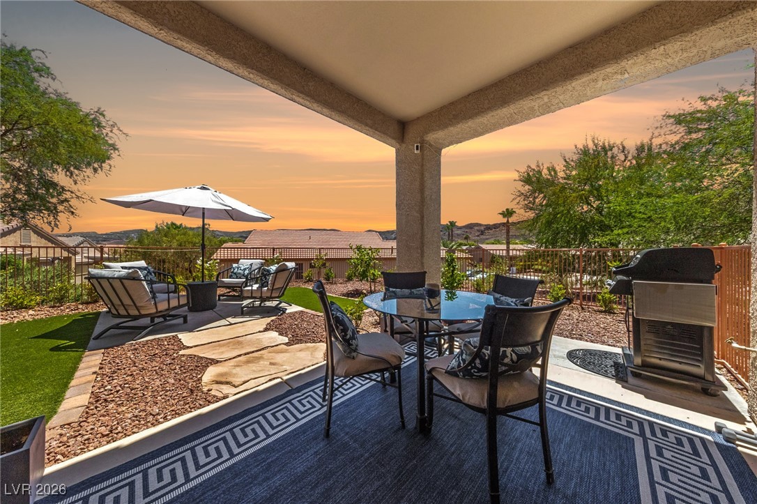 550 Kings Links Street Henderson, NV 89012 - Photo 23 of 36 Patio terrace at dusk featuring a patio, a fenced backyard, grilling area, and outdoor dining area