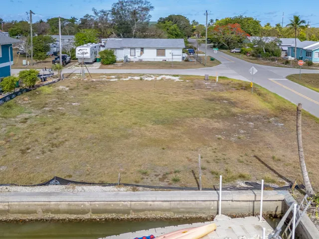a view of swimming pool with lawn chairs and plants