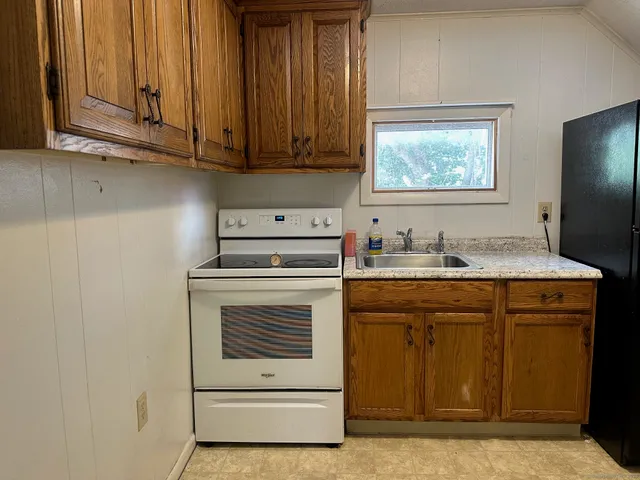 a kitchen with granite countertop cabinets stainless steel appliances and a sink