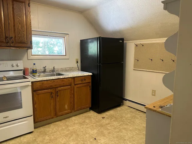 a kitchen with a refrigerator sink and cabinets