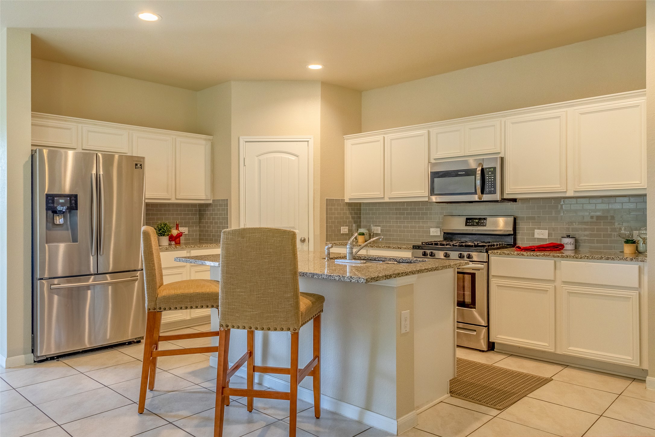 7225 Ranchito Drive Austin, TX 78744 - Photo 12 of 39 A gourmet kitchen showcasing granite counters, stainless steel appliances, and sleek tiled flooring.