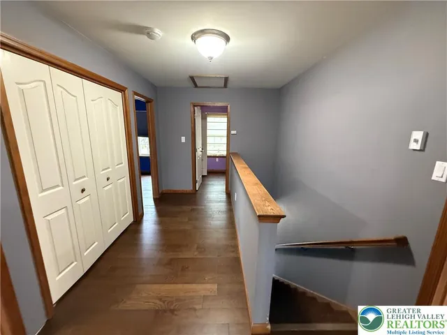 a view of a hallway with wooden floor and staircase
