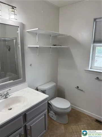 a bathroom with a toilet a sink and mirror