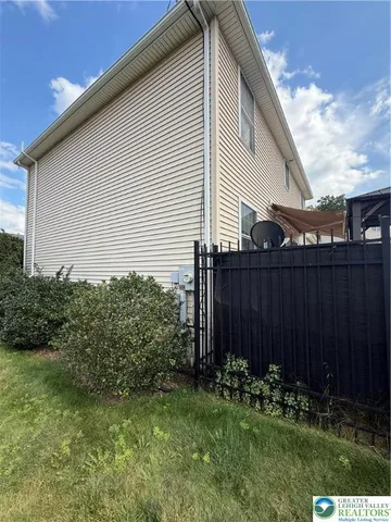a backyard of a house with plants and wooden fence