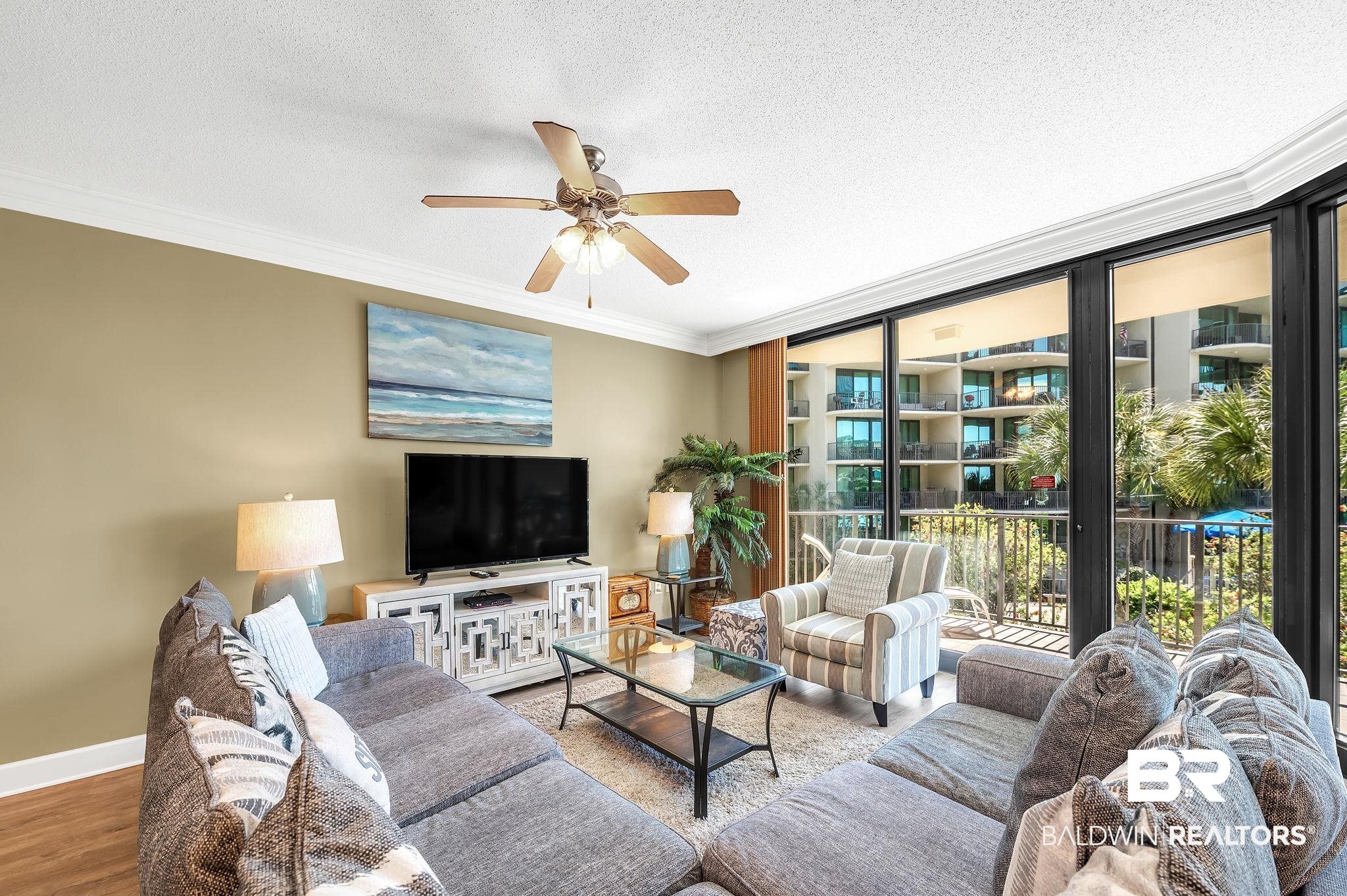 27580 Canal Road, Unit 1214 AND BOAT SLIP #62 Orange Beach, AL 36561 - Photo 12 of 67 Living room featuring crown molding, a textured ceiling, a ceiling fan, wood finished floors, and baseboards