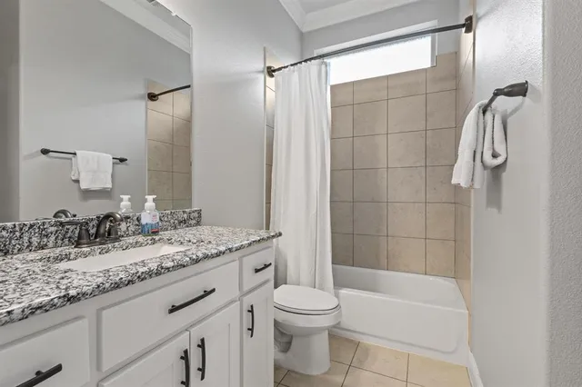 a bathroom with a granite countertop sink a toilet and shower