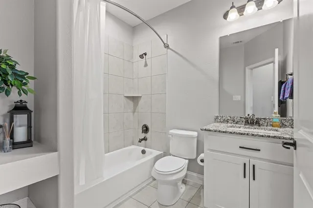 a bathroom with a granite countertop sink a toilet and shower