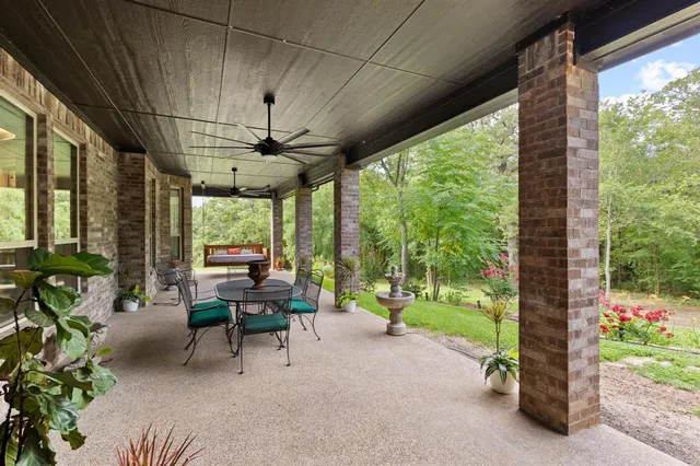 a view of a patio with a table chairs and a floor to ceiling window