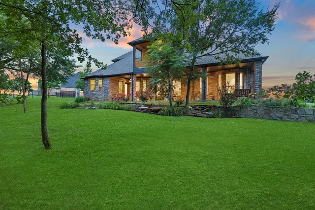 a front view of a house with a garden and trees