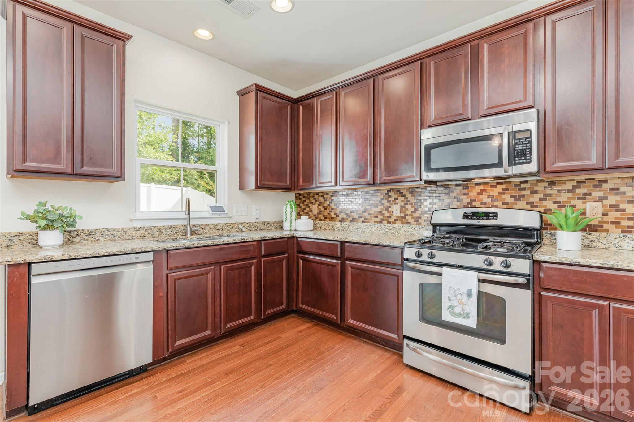 353 Chorus Road Fort Mill, SC 29715 - Photo 13 of 30 a kitchen with granite countertop wooden cabinets stainless steel appliances and a window