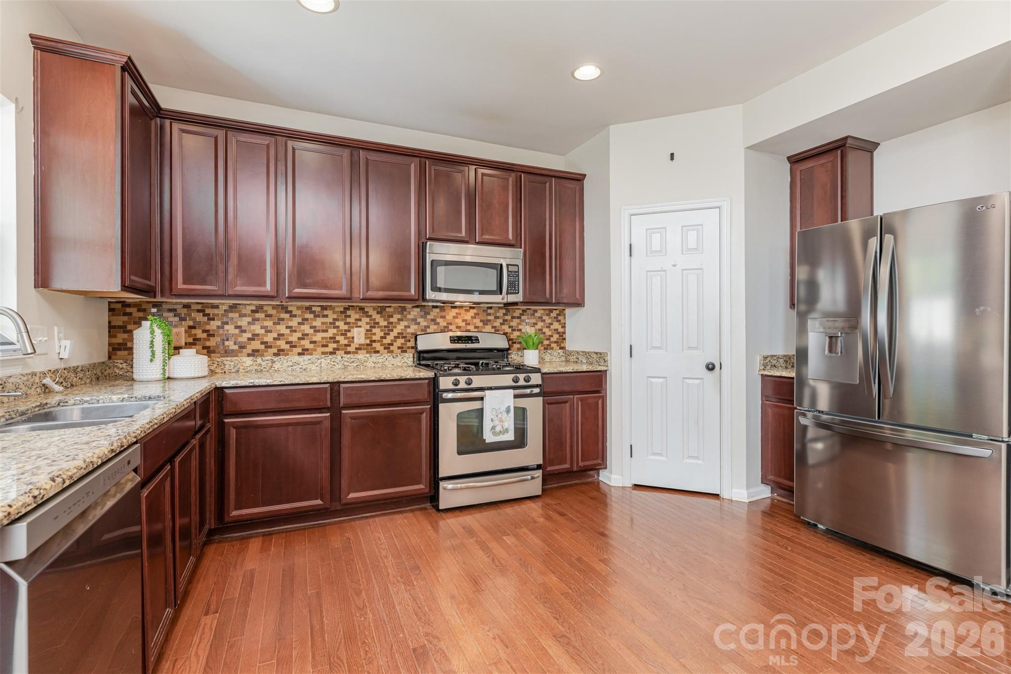 353 Chorus Road Fort Mill, SC 29715 - Photo 8 of 30 a kitchen with granite countertop wooden cabinets and stainless steel appliances
