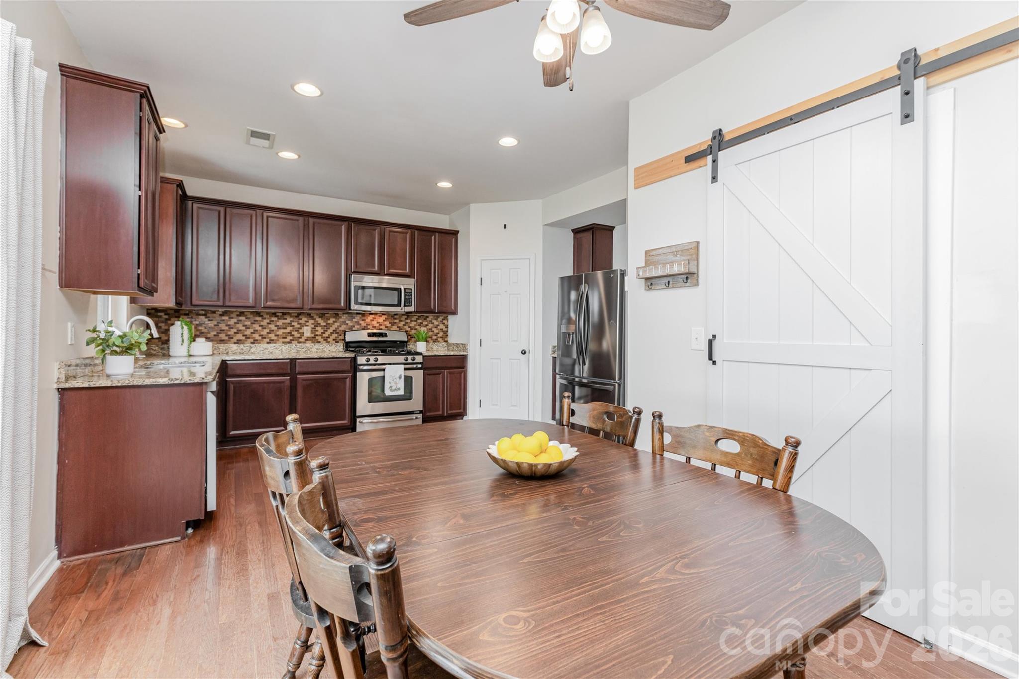 353 Chorus Road Fort Mill, SC 29715 - Photo 9 of 30 a kitchen with stainless steel appliances granite countertop a sink counter space and wooden floor