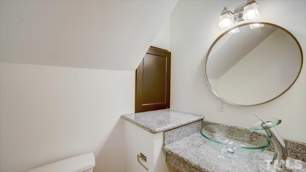 2504 Noble Road Raleigh, NC 27608 - Photo 11 of 28 a bathroom with a granite countertop sink and a mirror