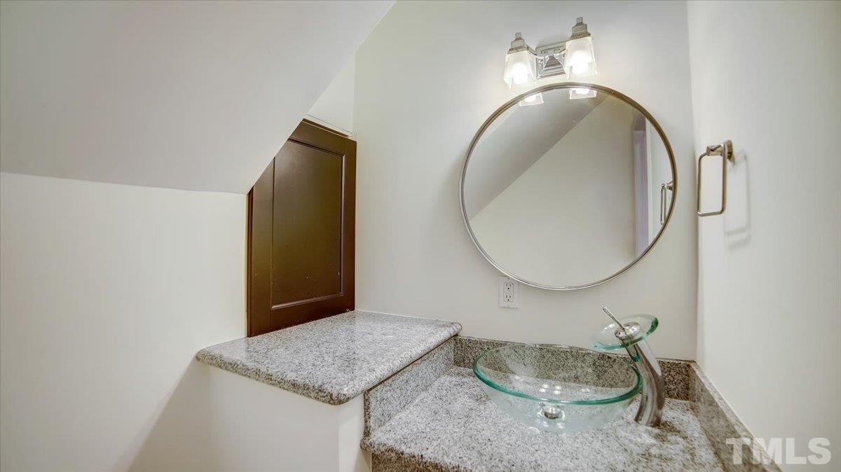 2504 Noble Road Raleigh, NC 27608 - Photo 12 of 28 a bathroom with a granite countertop sink and a mirror