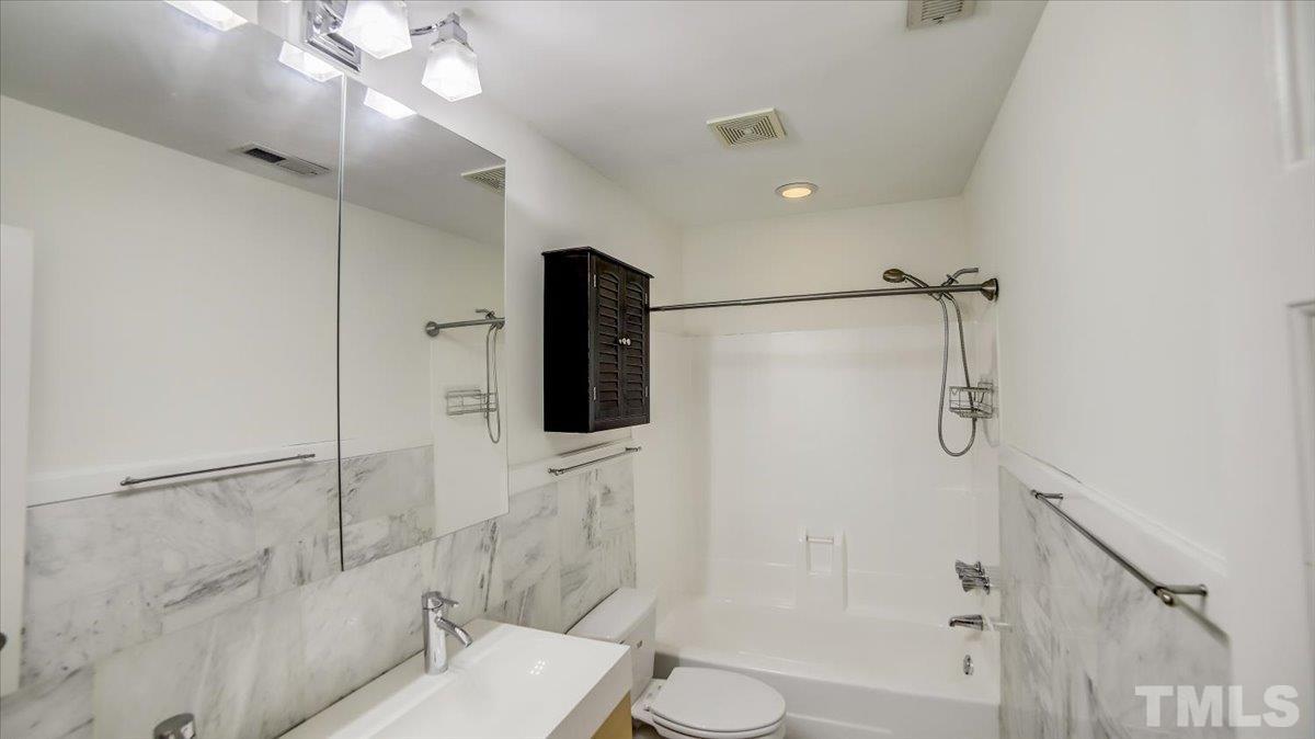 2504 Noble Road Raleigh, NC 27608 - Photo 16 of 28 a bathroom with a shower a toilet and sink