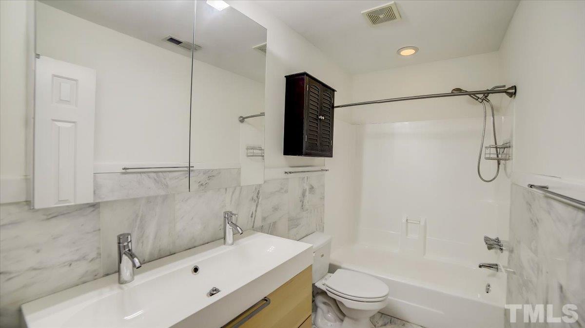 2504 Noble Road Raleigh, NC 27608 - Photo 17 of 28 a bathroom with a sink toilet tub and shower