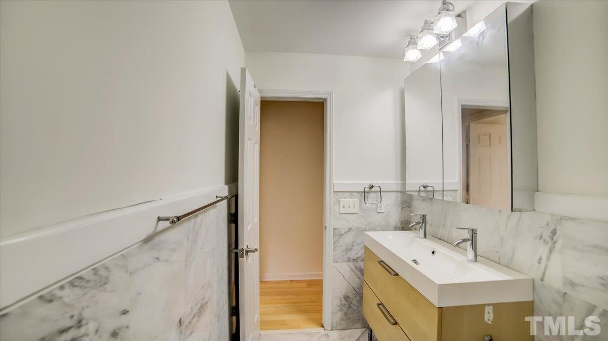 2504 Noble Road Raleigh, NC 27608 - Photo 18 of 28 a bathroom with a bathtub a sink and a mirror