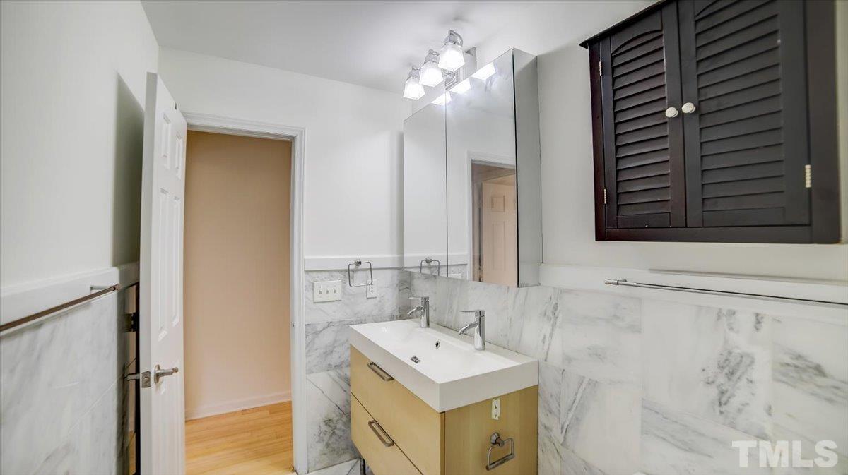 2504 Noble Road Raleigh, NC 27608 - Photo 19 of 28 a bathroom with a sink vanity and a mirror