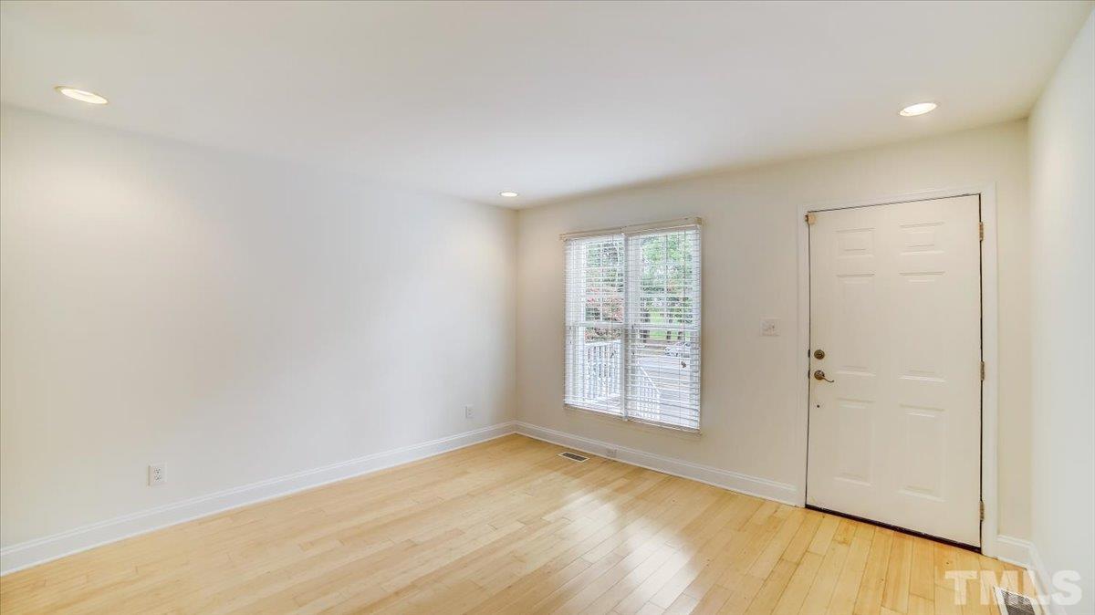 2504 Noble Road Raleigh, NC 27608 - Photo 3 of 28 an empty room with wooden floor and windows
