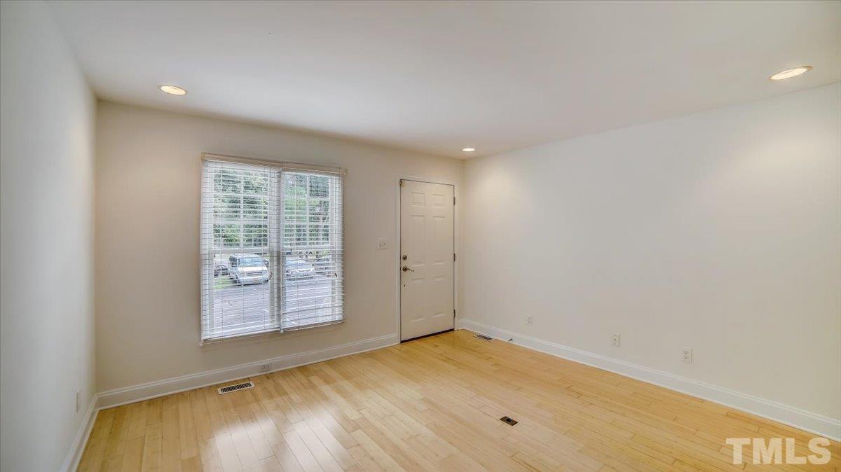 2504 Noble Road Raleigh, NC 27608 - Photo 4 of 28 an empty room with wooden floor and windows