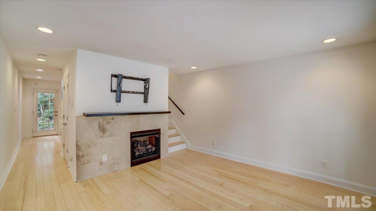 2504 Noble Road Raleigh, NC 27608 - Photo 5 of 28 a view of a livingroom with wooden floor and a fireplace